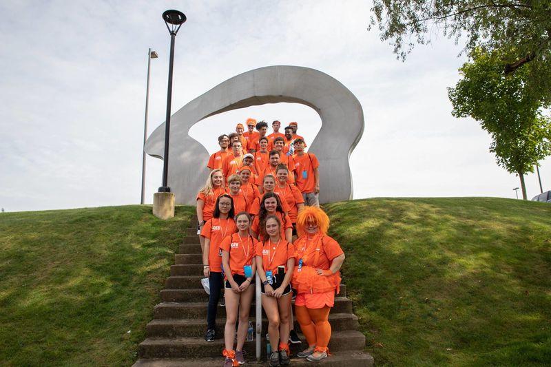 Students smiling by Arch statue