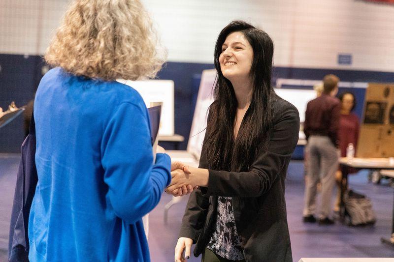 Two females shake hands