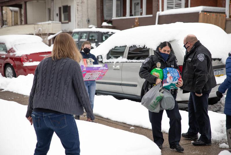 Individuals carrying gift bags and items