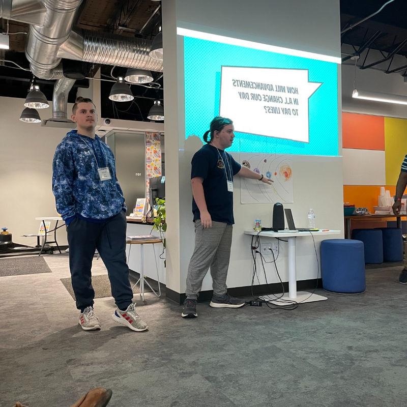 Students giving a presentation in front of a screen.