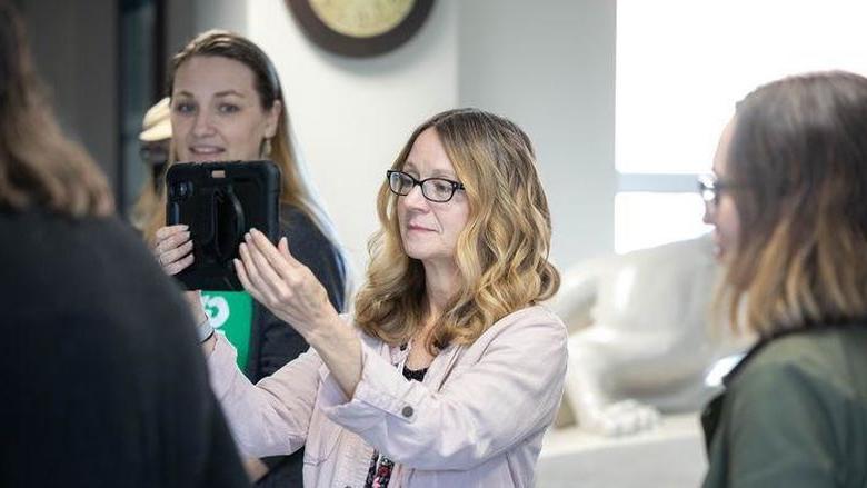 Individual holds tablet during augmented reality workshop