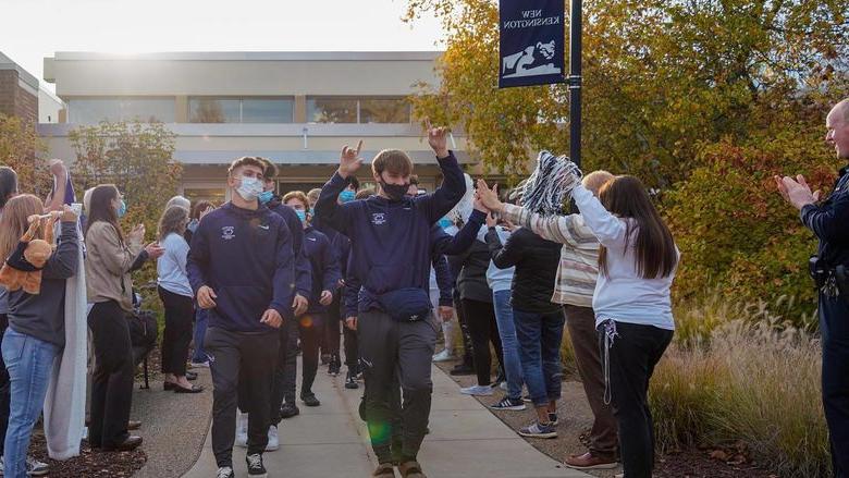 Men's soccer team walks through cheering crowd