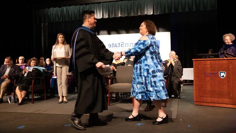 Woman accepts award from man on stage