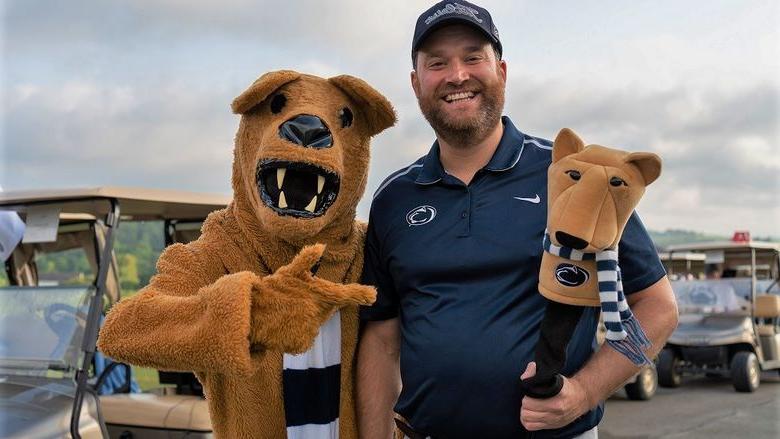 Man stands next to Nittany Lion mascot