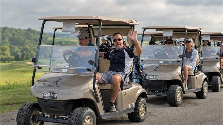 Man waves from golf cart