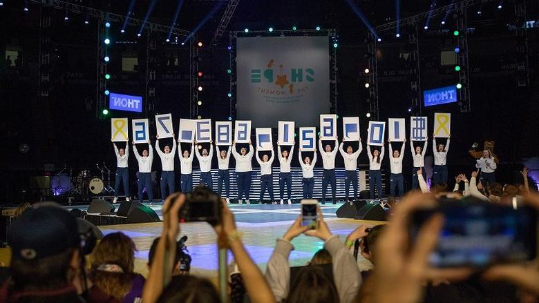 Students hold signs showing $10,621,683.76