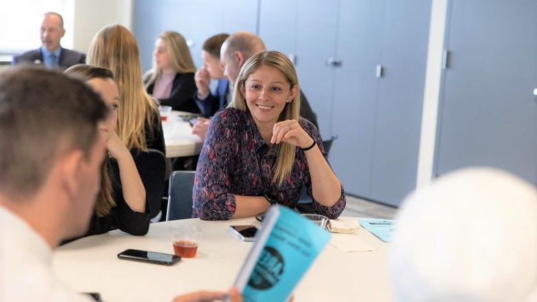 Female smiles while sitting at table