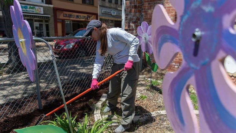 Woman spreads mulch in garden