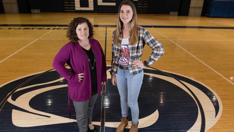 Two women standing in middle of gymnasium floor