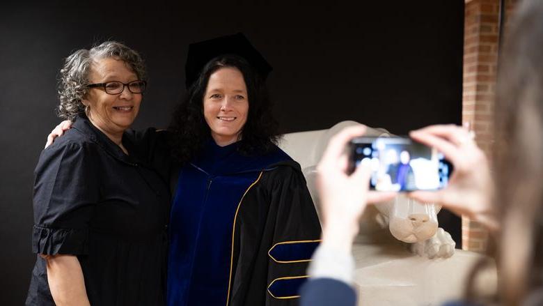 Two women stand together for photo