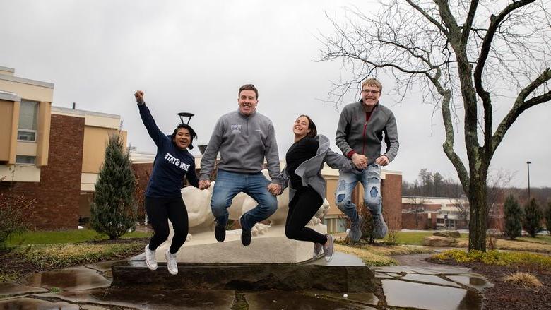 Four students jump in the air