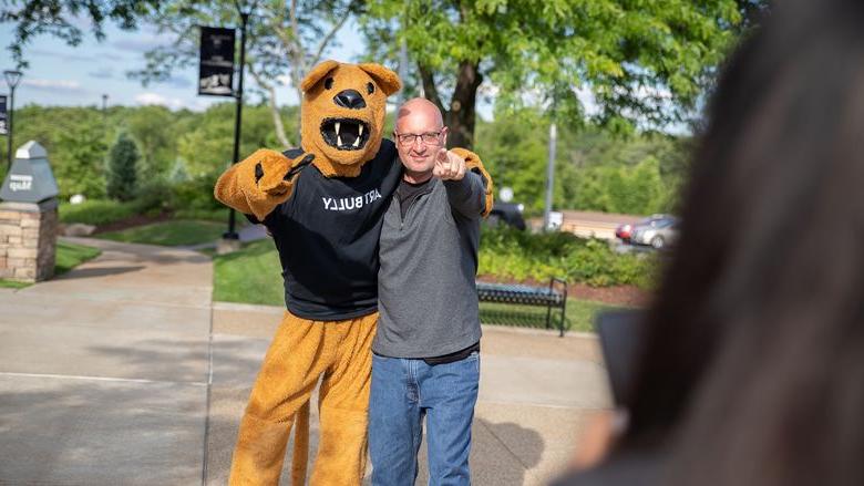 Man stands next to Nittany Lion mascot