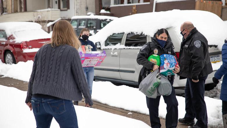 Individuals carrying gift bags and items