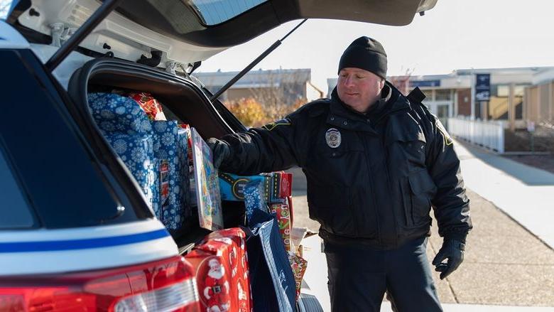 警察 officer puts gift in car