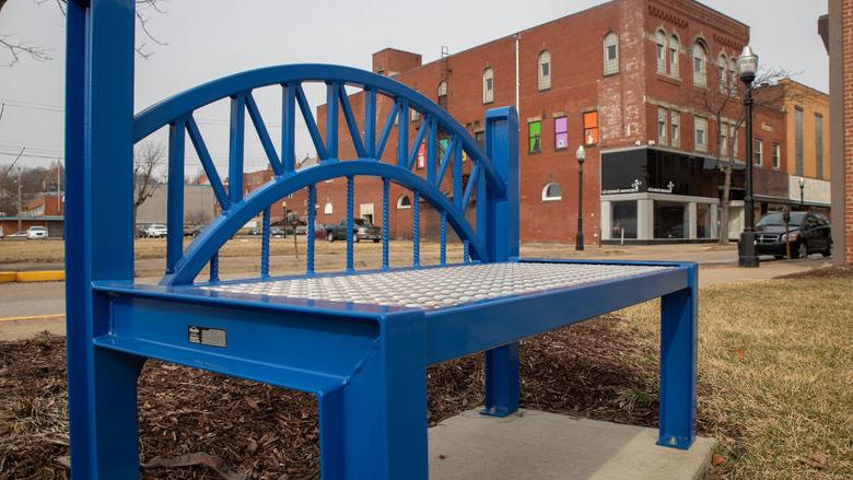 A blue bench along the sidewalk in 新肯辛顿