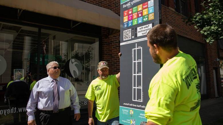 Three men look at street sign